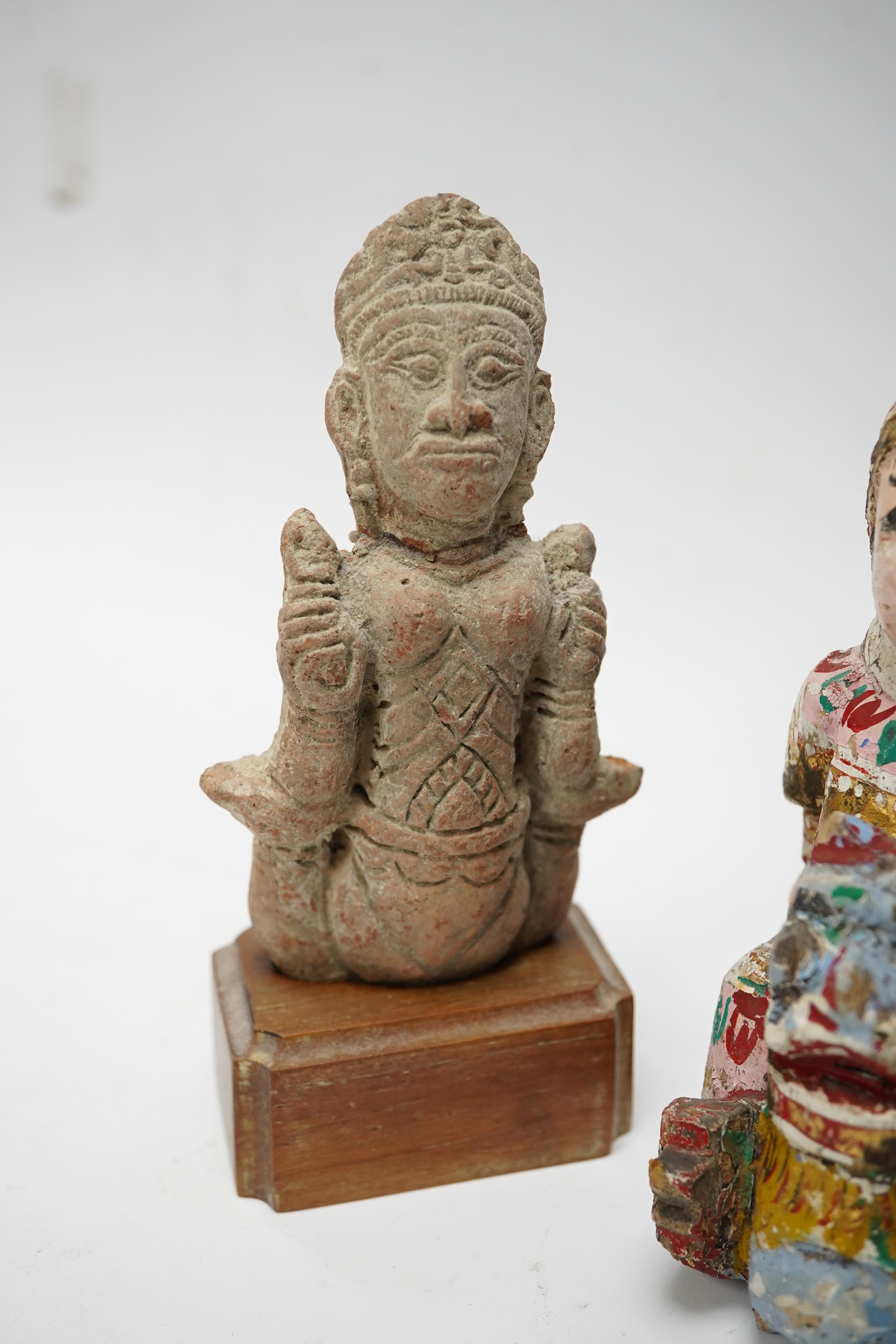 A Burmese lacquered wood figure, 19th century and an Indian terracotta figure of a deity, largest 13cm high overall. Condition - fair